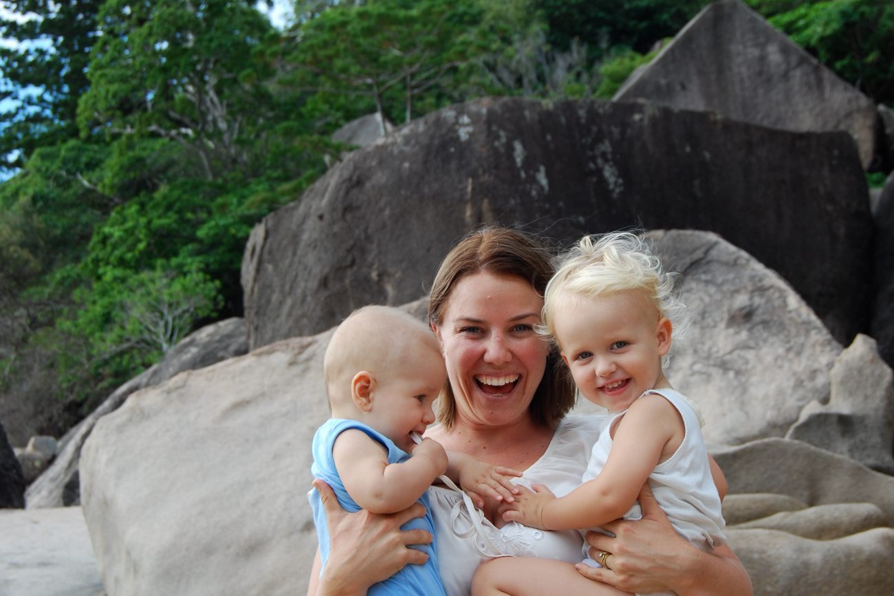 Tina Tower holding her two young sons on the beach